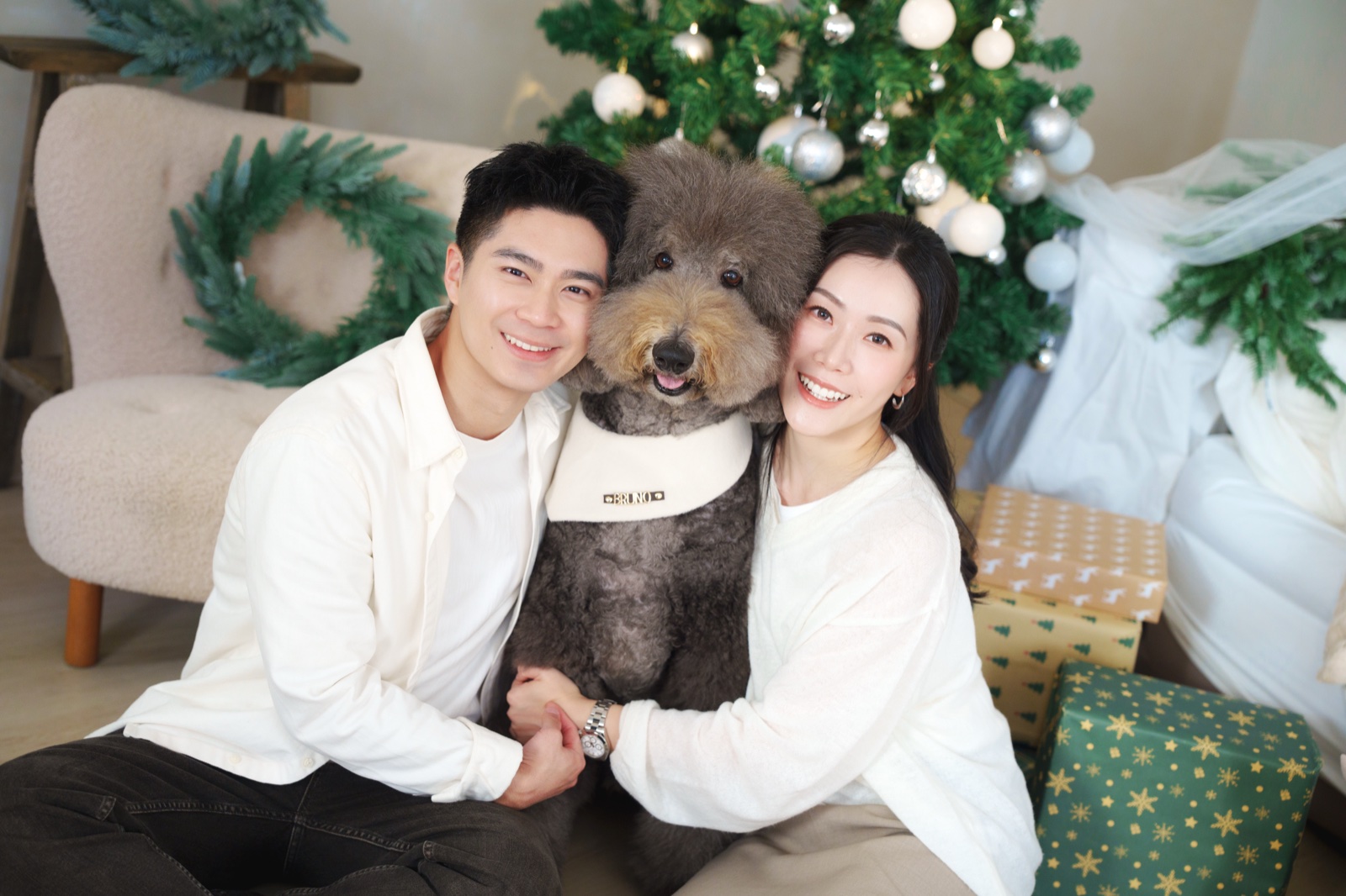 Chloe 與 Hansen 抱着愛犬,在聖誕樹和禮物旁合照