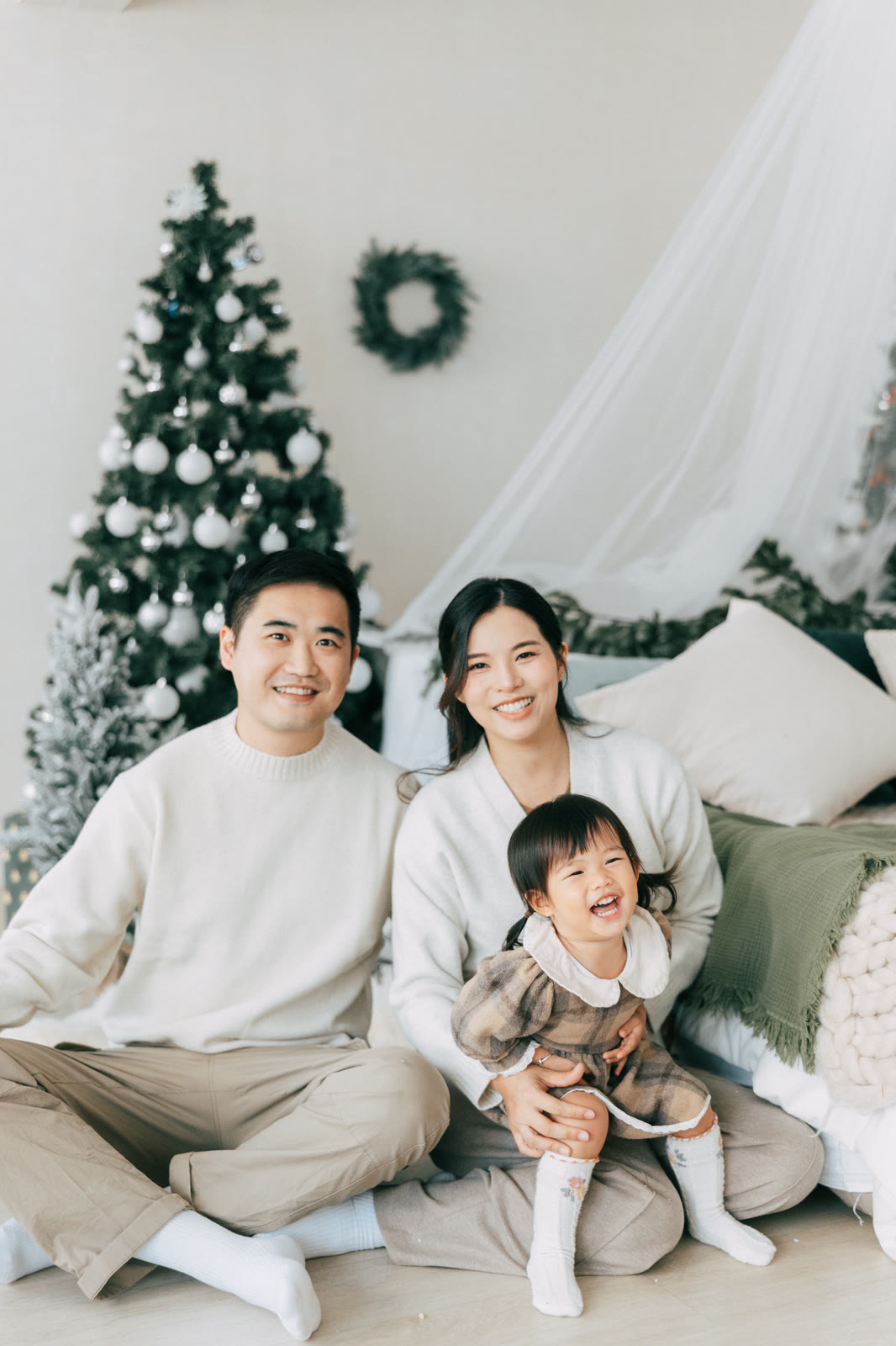 Lyla 一家三口坐在聖誕樹旁合照