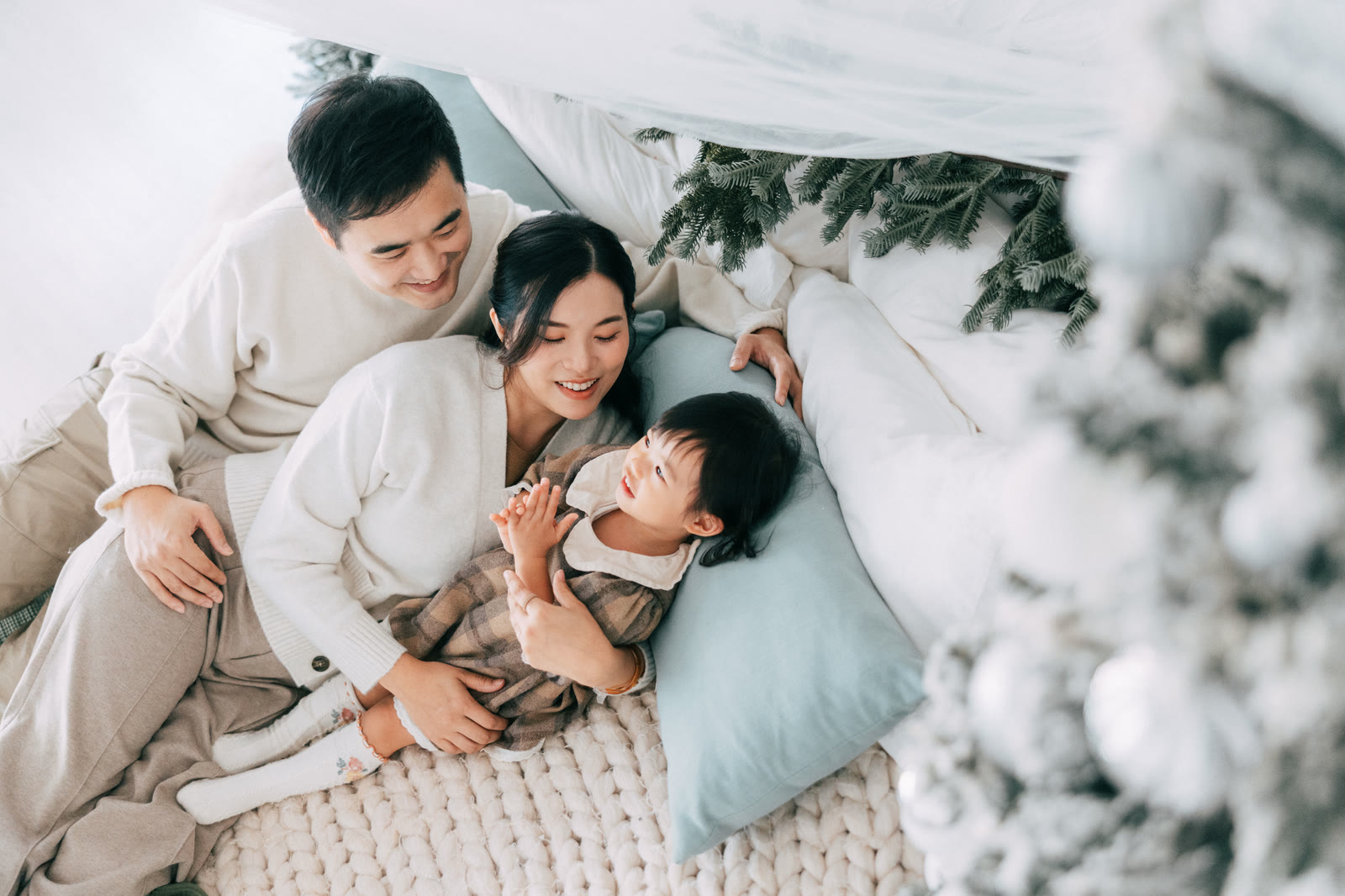 Lyla 一家三口在聖誕佈置的坐墊上依偎合照