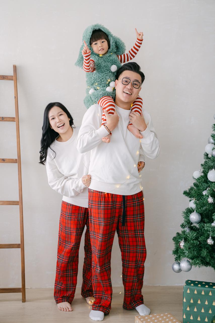 YatYat 一家在聖誕場景中合照,小朋友坐在大人肩膀上