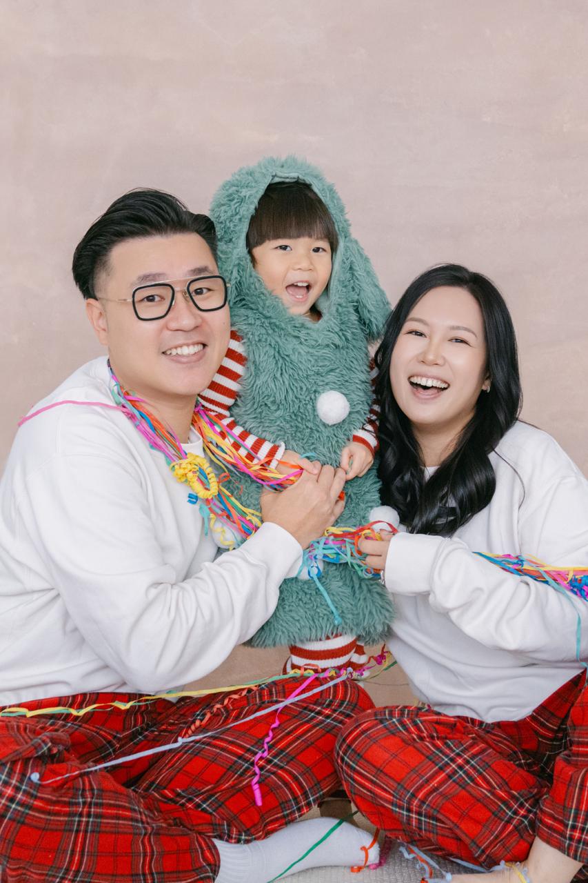YatYat 一家穿着聖誕主題服裝,圍坐在繽紛彩帶之中合照